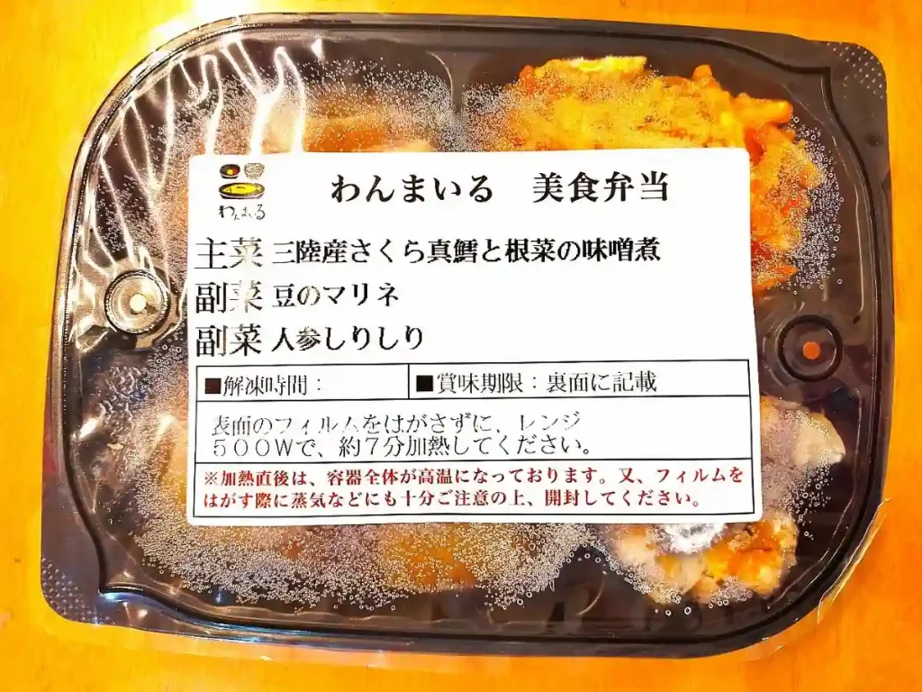 わんまいるの美食弁当。三陸産さくら真鱈と根菜の味噌煮を主菜に、豆のマリネ、人参しりしりが副菜として入った冷凍宅配弁当。フィルム包装で電子レンジ調理可能。