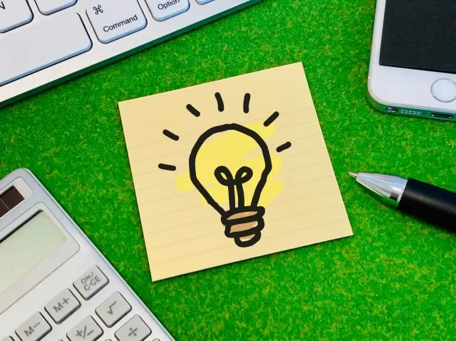 チェックポイントを示すような電球マークのメモと文房具の写真
