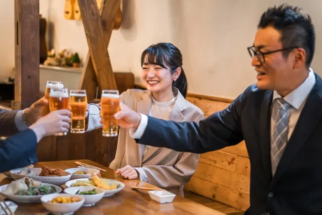 仲間とビールで乾杯しながら楽しく飲酒している様子