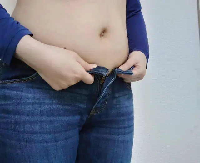 "ナッシュを食べているのに体重が減らず、ズボンがきつくなって悩んでいる様子"