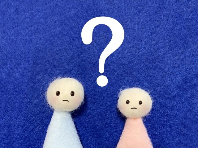 悩んだ表情の人形とクエスチョンマークのイラスト